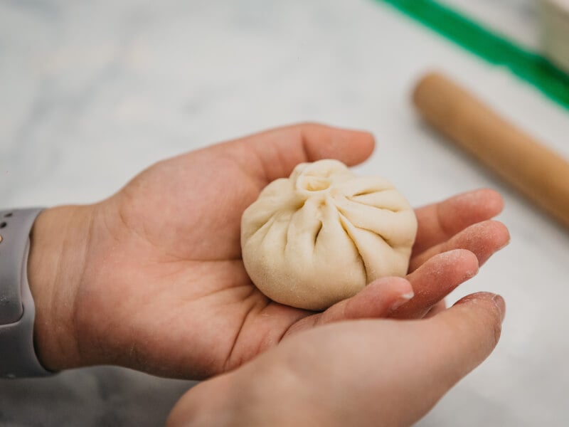 A handmade dumpling in a hand. 